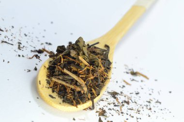 Beyaz arka planda bambu kaşığında çay.