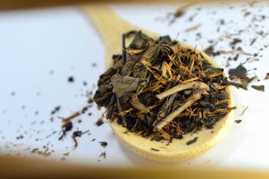 Beyaz arka planda bambu kaşığında çay.