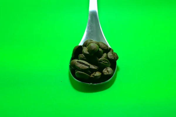 Koffiebonen Lepel Groene Achtergrond — Stockfoto