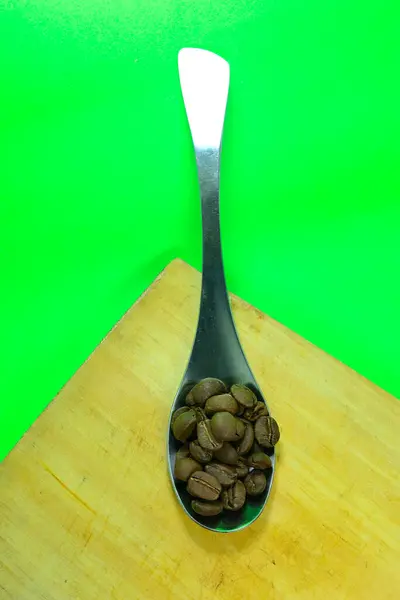 Koffiebonen Lepel Groene Achtergrond — Stockfoto