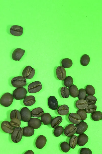 Spridda Kaffebönor Med Grön Bakgrund — Stockfoto