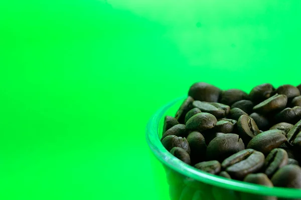 Kaffebönor Ett Genomskinligt Glas Ren Grön Bakgrund — Stockfoto