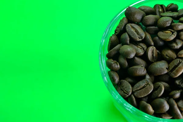 Kaffebönor Ett Genomskinligt Glas Ren Grön Bakgrund — Stockfoto