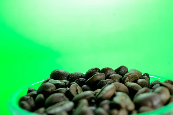 Kaffebönor Ett Genomskinligt Glas Ren Grön Bakgrund — Stockfoto