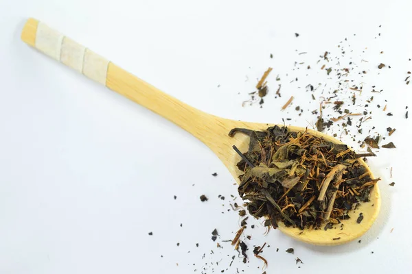 Beyaz arka planda bambu kaşığında çay.