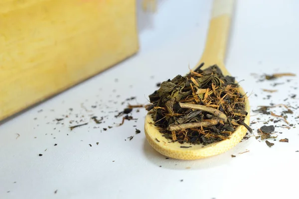 Beyaz arka planda bambu kaşığında çay.