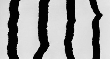 Dikey olarak yırtılmış kağıt parçaları. Ayrı siyah parçalar.