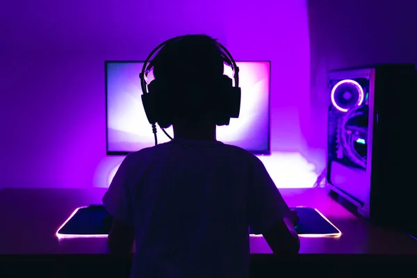 ゲーマーはPc上でゲームをプレイします 後ろからの眺め 紫のバックライトのローライトシーン — ストック写真