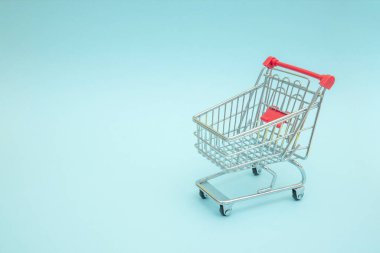 Empty shopping trolley with blue background