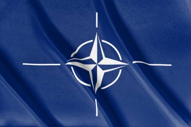Rüzgarda dalgalanan mavi bir NATO bayrağı 