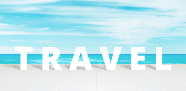 Travel text on white wooden surface front of blue sea and sky