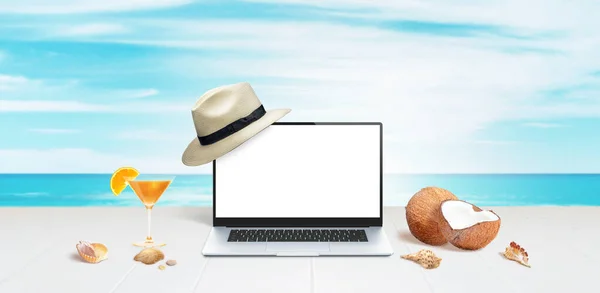 ココナッツ シェルとオレンジカクテルと白い表面に表示される白い帽子とノートパソコンのモックアップ — ストック写真
