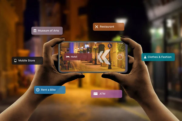 Finding hotels and other tourist facilities in the city with 3d navigation app based on augmented reality technology concept. Smartphone in a horizontal position in the hands of women. City street at night in background