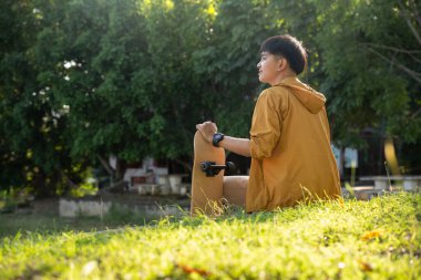Teenager playing skateboard at cement ground, extreme sport and outdoor activity.