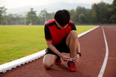 Koşmadan önce bağcıklarını bağlayan adamın elleri, spor, vücut ısısı ve egzersiz motivasyon konsepti..