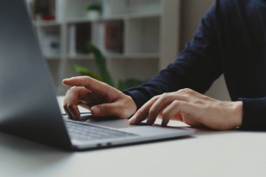 İş adamlarının elleri ev ofisini, çalışma sürecini ve sosyal ağ kavramını gösteren dizüstü bilgisayara işaret ediyor.