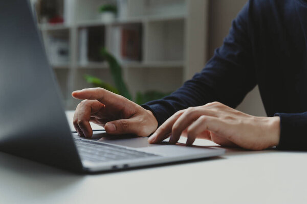 Hand of businessman pointing to laptop screen at home office, work process and social network concept.