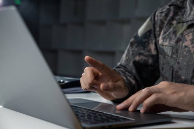 Karşıt bilgi kavramının izlenmesi ve kontrolü, dizüstü bilgisayara işaret eden genç askerin eli.
