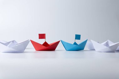 Liderlik ve takım çalışması kavramı, kırmızı, mavi ve beyaz kağıt gemi. Beyaz arkaplanda liderlik kavramı.