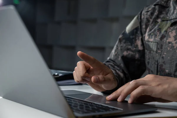 Surveillance and control of opposing information concept, Hand of young soldier pointing to laptop screen.