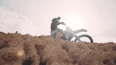 Motocross rider on his bike ready to race in dirt track, sport extreme and travel adventure concept.