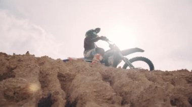 Motocross rider on his bike ready to race in dirt track, sport extreme and travel adventure concept.