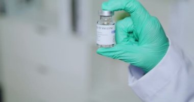 Hand of scientist or doctor holding COVID-19 vaccine bottle, prepare to be injected into people.