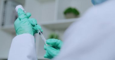COVID-19 aşı şişesi ve şırıngası tutan bilim adamı veya doktorun eli, insanlara enjekte edilmeye hazır olun..