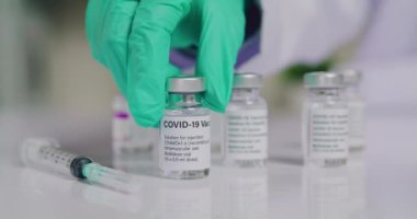 Hand of scientist or doctor holding COVID-19 vaccine bottle, prepare to be injected into people.