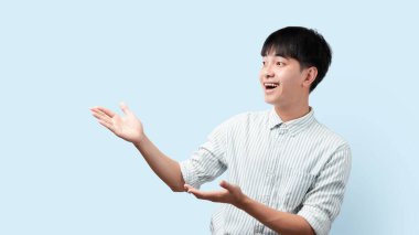 Asyalı yakışıklı bir adamın portresi, el ele tutuşurken, Asyalı bir adamın mavi arka planda durduğunu gösteriyor..