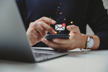 İş adamının eli, bildirim uyarısı ve online iletişim konsepti ile akıllı telefonu e-posta olarak kullanıyor.