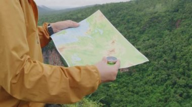 Pusula ve harita gezginlerin elinde kamp yaparken dağın tepesindeki konum ve yönü kontrol etmek ve aramak için.