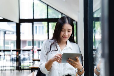 Ofiste dijital tabletle çalışan Asyalı iş kadını, başlangıç işi ve kişisel mali muhasebe kavramı.