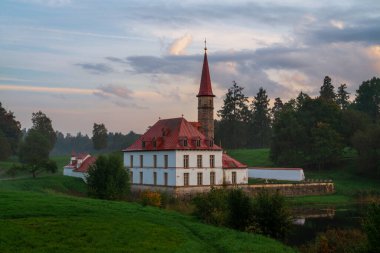 Gatchina, St. Petersburg, Rusya 'da bir sonbahar sisli akşamında, Kara Göl kıyısındaki Manastır Sarayı' nın arka planında günbatımı gökyüzünün görüntüsü