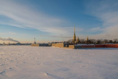 Peter ve Paul Kalesi ve Vasilievsky Adası 'nın güneşli bir kış sabahı bulutlu Neva Nehri üzerindeki Üçlemeci Köprüsü' nden görünüşü, St. Petersburg, Rusya