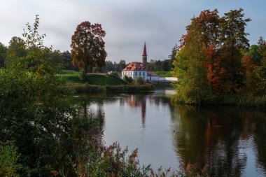 Kara Göl kıyısındaki Manastır Sarayı manzarası güneşli bir sonbahar akşamında bulutlar, Gatchina, St. Petersburg, Rusya