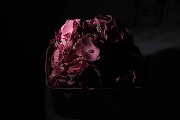 Siyah arka planda bir buket suni çiçek.