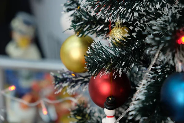 Parlak çelenklerle süslenmiş yeşil ağaç dallarına Noel süsleri