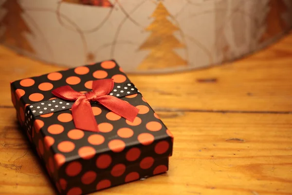 Paketinde kırmızı kurdele olan bir hediye.