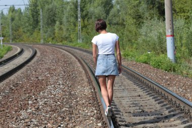 Demiryolunda yürüyen bir kız.