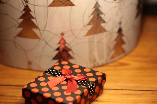 Kırmızı kurdeleyle sarılmış kırmızı hediye paketi.