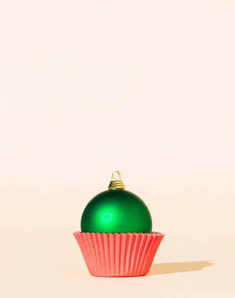 Noel mücevheri ve kağıt kek fincanı ile bayram minimal fikri. Kutlama zamanı. Yeni yıl konsepti. Boşluğu kopyala.