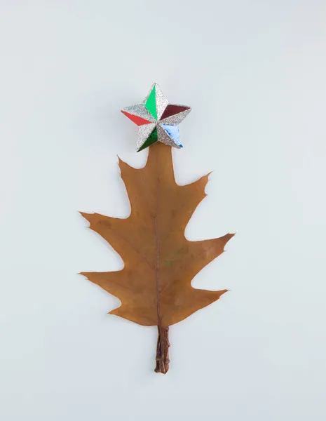 Beyaz arka planda akçaağaç yaprağından yapılmış Noel ağacı. Düz yatıyordu. Yeni yıl doğası minimum konsept.