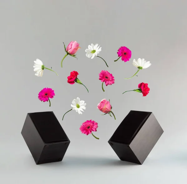 Modern audio speakers with various spring flowers on grey background. Minimal spring vibe concept. Sounds of spring and fresh ideas. Valentines day or 8 March card.