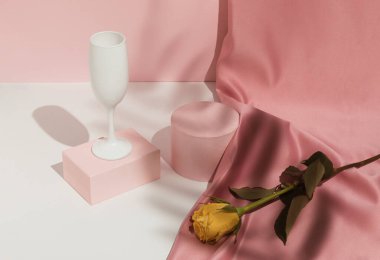 Romantik pastel pembe sevgililer günü kompozisyonu şarap kadehleri, saten perdeler ve sarı gül çiçekleri. Ürün Gösterimi ve İş Konsepti için uygundur. Modern estetik.