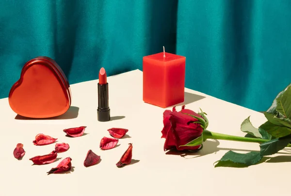 キャンドル ギフトボックス 口紅と明るいベージュのテーブルに赤いバラの花とロマンチックな組成物 絹の緑のカーテンの背景 バレンタインデーのコンセプト — ストック写真