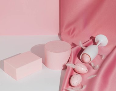 Şarap kadehli, saten perdeli, yumurta ve tüylü pastel pembe Paskalya kompozisyonu. Ürün Gösterimi ve İş Konsepti için uygundur. Modern estetik. Mutlu Paskalyalar.