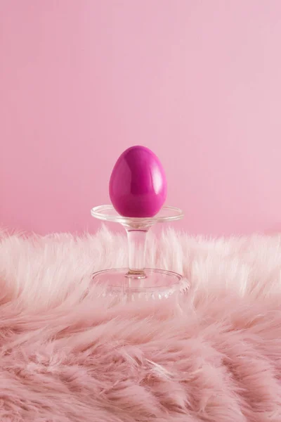 表彰台とピンクの毛皮の背景に描かれた卵で作られたイースターの組成物 最小限の休日の概念 — ストック写真