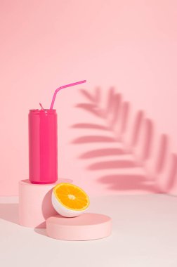 Ürün podyumu ve gölgesinde yarı portakal meyveli pembe teneke kutu. Yaz içkisi konsepti çok az. Pembe estetik..