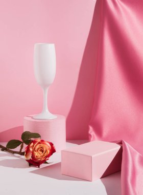 Romantic pastel pink composition with glass, satin curtain and rose flower. Suitable for Product Display and Business Concept. Modern aesthetic.